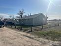 Simple single-story home with a rustic fence and a spacious dirt yard at 1306 Main St, Platteville, CO 80651