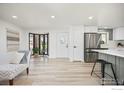 Bright open floor plan featuring wood flooring, a stainless refrigerator, a kitchen island, and natural light at 1643 Vivian St, Longmont, CO 80501