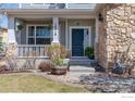 Inviting front porch with stone accents and lovely landscaping elements at 16518 Red Rock Ln, Broomfield, CO 80023