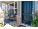 Welcoming front porch with seating area and a stylish blue front door at 16518 Red Rock Ln, Broomfield, CO 80023