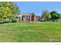 Charming brick home featuring a well-manicured lawn and welcoming front entrance at 18399 Wagon Trl, Mead, CO 80542