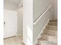 Light and airy entryway with neutral walls, carpeted stairs, and wood-look floors at 255 Mayfly Ln, Berthoud, CO 80513
