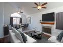 Bright living room features vaulted ceiling, fireplace, ceiling fans, and dining area at 3342 W 114Th Pl, Westminster, CO 80031