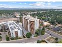 Aerial view showcasing the condo building, its architectural design, surrounding greenery, and city skyline at 4570 E Yale Ave # 1104, Denver, CO 80222