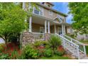 Charming two-story home featuring a covered front porch with stone accents and beautiful landscaping at 4921 Fountain St, Boulder, CO 80304
