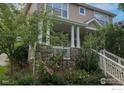 Charming home featuring a stone porch with lovely landscaping including rose bushes and trees at 4921 Fountain St, Boulder, CO 80304