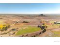 Aerial shot showing property lines, with open land, scattered trees, ponds, and mountain views at 5196 Oxford Rd, Longmont, CO 80503
