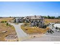 Expansive home featuring stone accents, covered patio, beautiful landscaping, and circular driveway at 6689 Asher Ct, Longmont, CO 80503