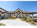 Stunning home featuring stone accents, covered patio, professional landscaping, and an extended circular driveway at 6689 Asher Ct, Longmont, CO 80503