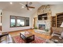 Living room features a stone fireplace, high ceilings, and plenty of natural light at 7777 Aggregate Blvd, Erie, CO 80516