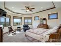 A carpeted primary bedroom with natural light, a ceiling fan, and wooden trim at 7777 Aggregate Blvd, Erie, CO 80516