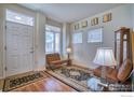 Bright foyer with laminate floors, a stylish rug, and a comfortable seating area near the front door at 835 Kane Dr # 25, Longmont, CO 80501