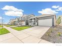 A quiet street featuring single Gathering homes with well-kept lawns, driveways, and landscaping at 852 Leeward St, Lochbuie, CO 80603