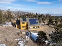 Expansive aerial view showcasing the home, large windows and the mountain landscape at 1335 Deer Trail Rd, Boulder, CO 80302