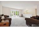 Open living room with neutral carpet, comfortable sofas, and a bay window providing plenty of natural light at 1518 Vivian St, Longmont, CO 80501