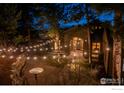 Exterior home elevation at dusk featuring charming string lights and stone accents at 1782 Tulip Tree Pl, Castle Rock, CO 80108