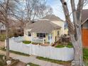 Charming two-story yellow home with a white picket fence and welcoming front porch at 2121 Grove Cir, Boulder, CO 80302