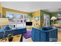 Bright living room featuring plush blue sofas, large windows, and colorful modern decor at 2276 Goss Cir, Boulder, CO 80302