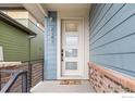 Stylish front door with frosted windows, complemented by blue siding and brick accents at 2341 Feathergrass Ln, Superior, CO 80027