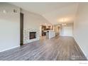 Bright open-concept living room featuring a fireplace and views of the kitchen and dining area at 2435 Calais Dr # A, Longmont, CO 80504