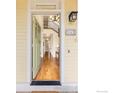 View into the home's entryway showcasing the hardwood floors, staircase, and stylish lighting at 245 Spruce St, Louisville, CO 80027