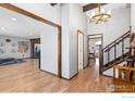 Inviting hallway featuring hardwood floors, staircase, and views into other rooms at 2819 Lake Park Way, Longmont, CO 80503
