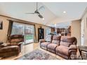 Bright living room with hardwood floors, vaulted ceiling, and a sliding glass door to the backyard at 357 W Harper St, Louisville, CO 80027