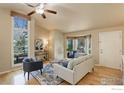 Bright living room with vaulted ceilings, hardwood floors, and natural light from large windows at 387 Buchanan Ct, Louisville, CO 80027