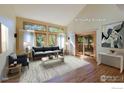 Staged living room with many windows providing natural light, hardwood floors and stylish furniture at 3895 Norwood Ct, Boulder, CO 80304
