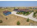 Expansive aerial view of the blue home with a detached garage and private surrounding acreage at 3967 Eastout Ave, Parker, CO 80138
