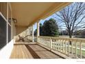 Inviting front porch with wooden flooring, white railing, and a view of the neighborhood at 4215 Bella Vista Dr, Longmont, CO 80503