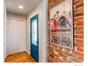 Entryway with beautiful hardwood floors, brick wall, and a stylish blue door at 4337 Umatilla St, Denver, CO 80211
