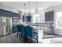 Bright, modern kitchen with navy blue cabinetry, stainless steel appliances, kitchen island, and pendant lighting at 438 Meridian Ln, Superior, CO 80027