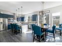 Spacious kitchen with dining area, blue cabinetry, stainless steel appliances, and contemporary pendant lighting at 438 Meridian Ln, Superior, CO 80027