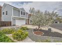 Beautifully landscaped front yard with a mature tree and decorative rock accents at 5275 Holmes Pl, Boulder, CO 80303