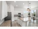 Bright kitchen featuring white cabinetry, granite countertops, and stainless steel appliances at 701 Lene Ln, Berthoud, CO 80513