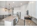 Well-lit kitchen featuring granite countertops, stainless steel appliances, and a large island at 701 Lene Ln, Berthoud, CO 80513