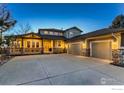 Inviting two-story home featuring a large driveway and charming front porch with stone accents at 7947 Ute Hwy, Longmont, CO 80503