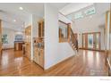 Spacious foyer with hardwood floors, staircase, and built-in bar area, creating an elegant entrance at 7947 Ute Hwy, Longmont, CO 80503