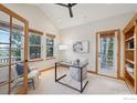 Bright office space with vaulted ceilings, large windows, and a glass-topped desk, perfect for productivity at 7947 Ute Hwy, Longmont, CO 80503