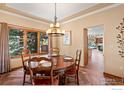 Dining room with a round table, wood chairs, and a large window providing natural light at 7959 Nile Ct, Arvada, CO 80007