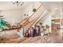 Bright foyer features wood floors, staircase, and decoratively adorned with potted plants and vases at 7959 Nile Ct, Arvada, CO 80007