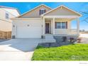 Inviting two-story home with a charming front porch, fresh lawn, and a two car garage at 817 Ledge St, Lochbuie, CO 80603
