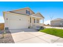 Inviting two-story home with a charming front porch, fresh lawn, and a two car garage at 817 Ledge St, Lochbuie, CO 80603