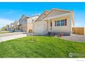 Inviting two-story home with a charming front porch, fresh lawn, and a two car garage at 817 Ledge St, Lochbuie, CO 80603