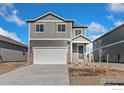 Charming two-story home featuring stone accents, a two-car garage, and gray woodgrain siding at 864 Leeward St, Lochbuie, CO 80603
