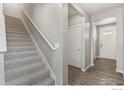 Bright hallway featuring wood-look floors, stairs and gray walls at 864 Leeward St, Lochbuie, CO 80603