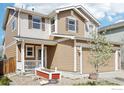 Two-story home with a two-car garage, covered porch, and a blossoming tree in the front yard at 10433 Forester Pl, Longmont, CO 80504