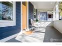 Inviting front porch with seating area, featuring a bright yellow front door at 1109 Main St, Louisville, CO 80027