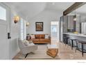 Open-concept living room with hardwood floors, modern decor, and vaulted ceiling at 1109 Main St, Louisville, CO 80027